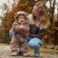 Una mamma con un bambino che indossa una tutina in pile