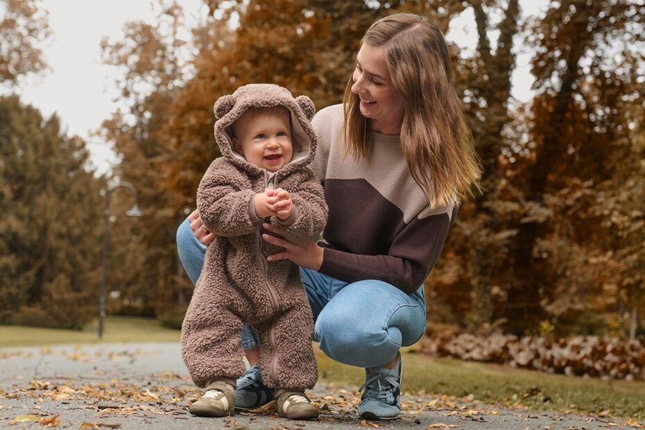 Una mamma con un bambino che indossa una tutina in pile